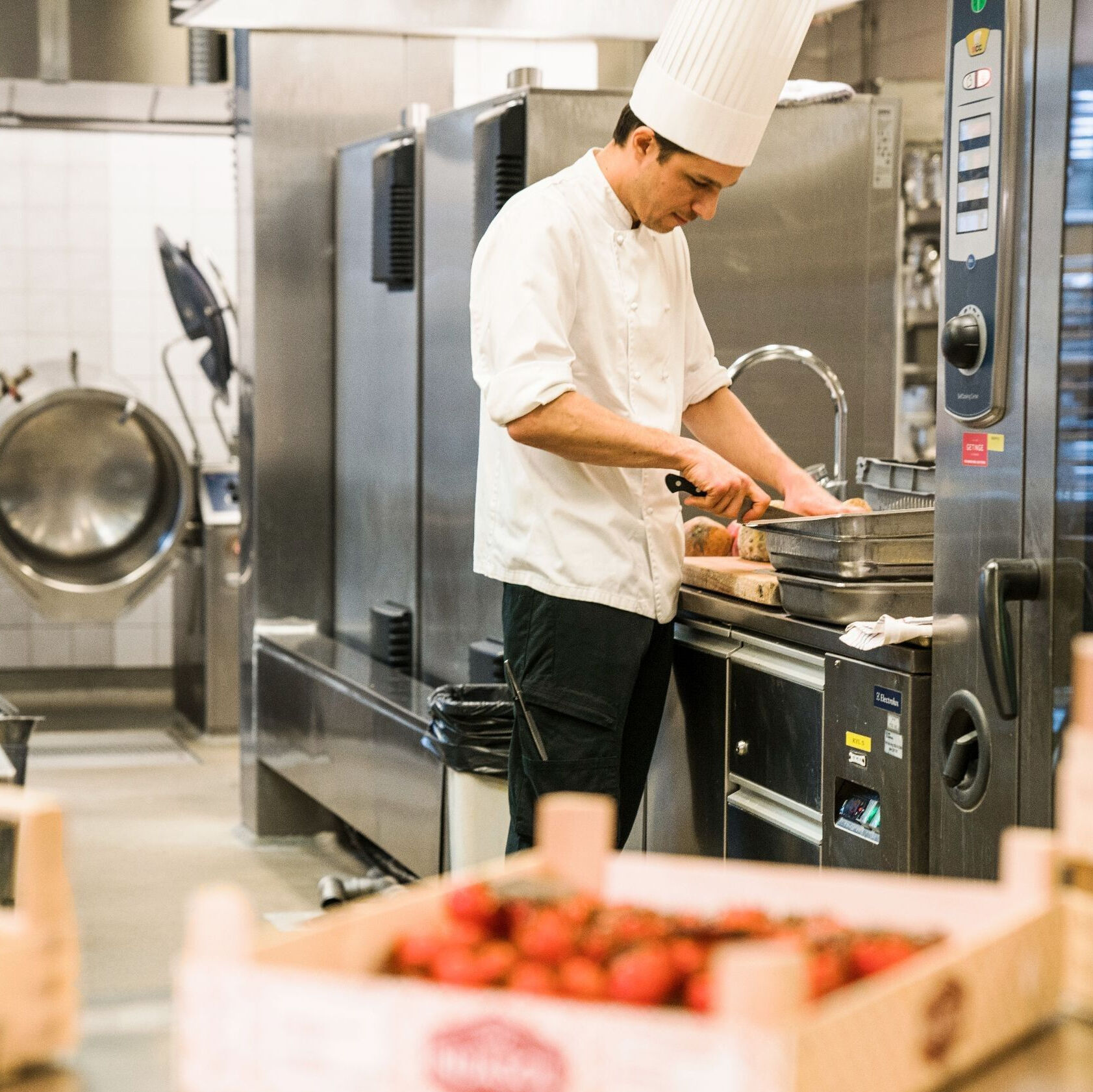 Kock som skär bröd i ett restaurangkök på Hotel Tylösand