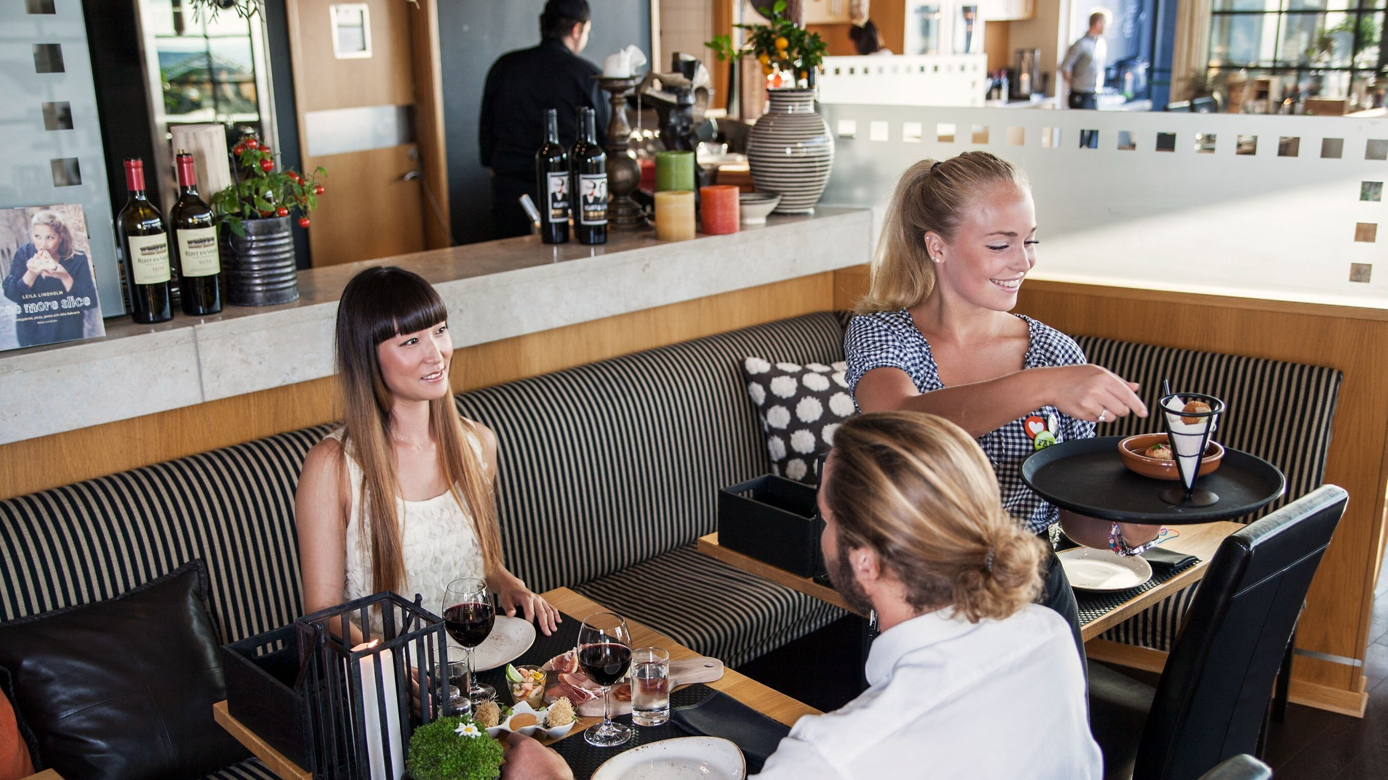 Hotel Tylösand servitris serverar mat till gäster i restaurangen