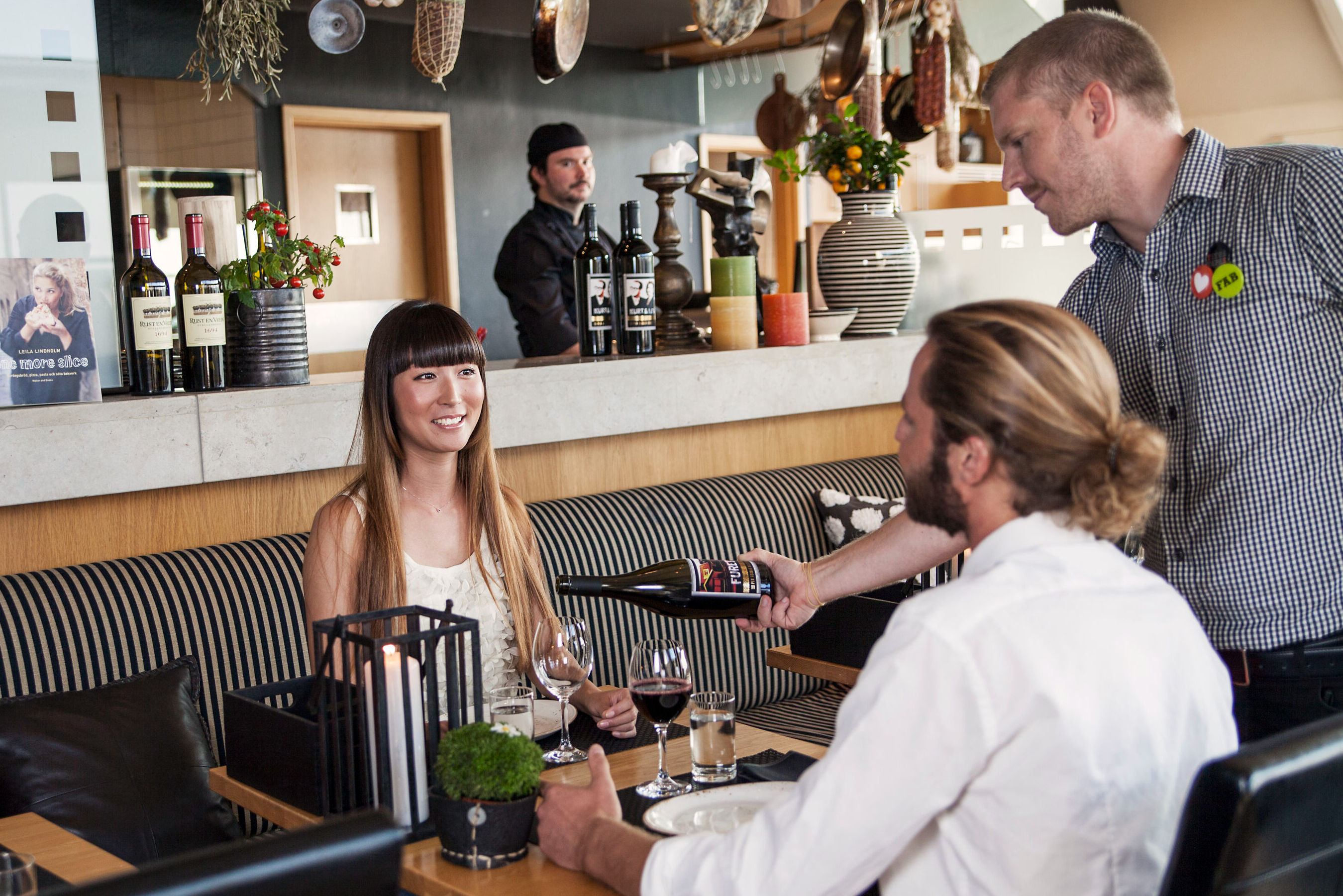 Hovmästare serverar vin för ett par.